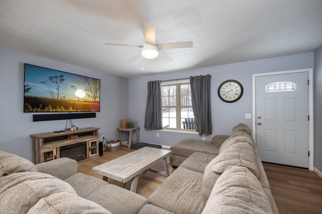 living area with a textured ceiling, ceiling fan, and wood finished floors