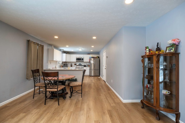 dining area featuring recessed lighting, light wood-style floors, and baseboards