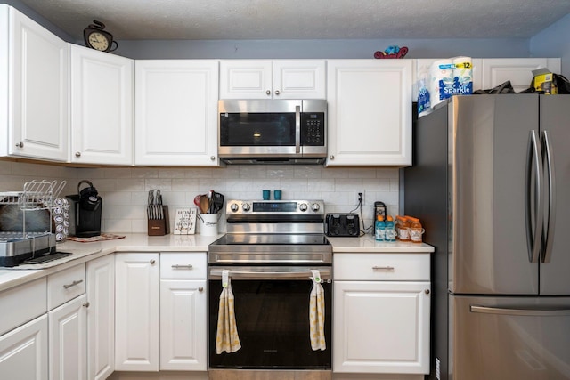 kitchen featuring light countertops, white cabinets, backsplash, and stainless steel appliances