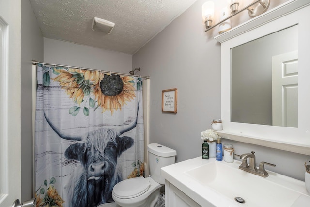 full bathroom with toilet, vanity, and a textured ceiling