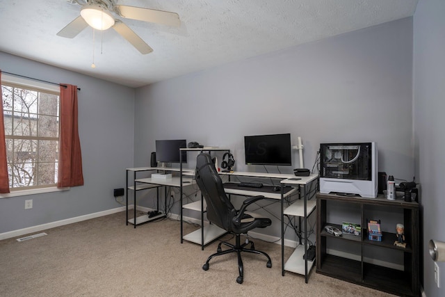 carpeted home office featuring visible vents, baseboards, a textured ceiling, and a ceiling fan