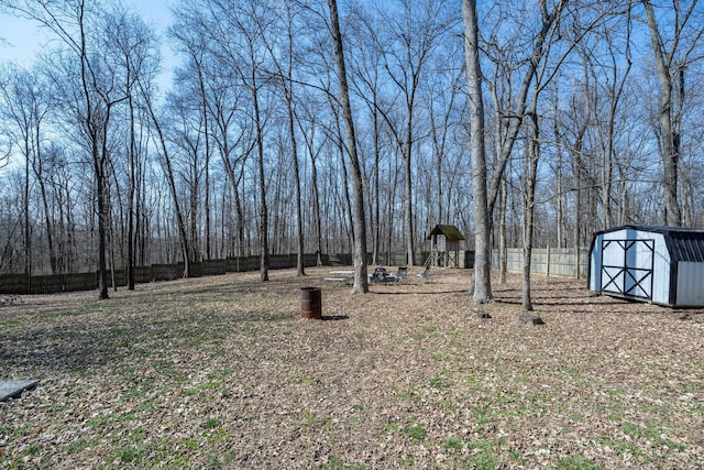 view of yard with a storage shed, an outdoor structure, and fence