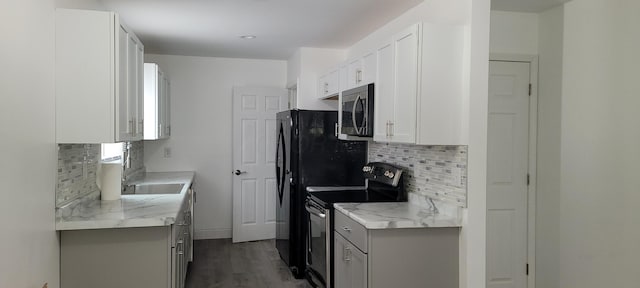 kitchen with light stone counters, white cabinetry, stainless steel appliances, and tasteful backsplash