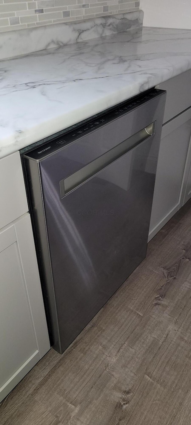 room details with dishwasher, white cabinets, and light hardwood / wood-style flooring