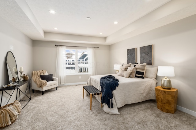 carpeted bedroom with a raised ceiling