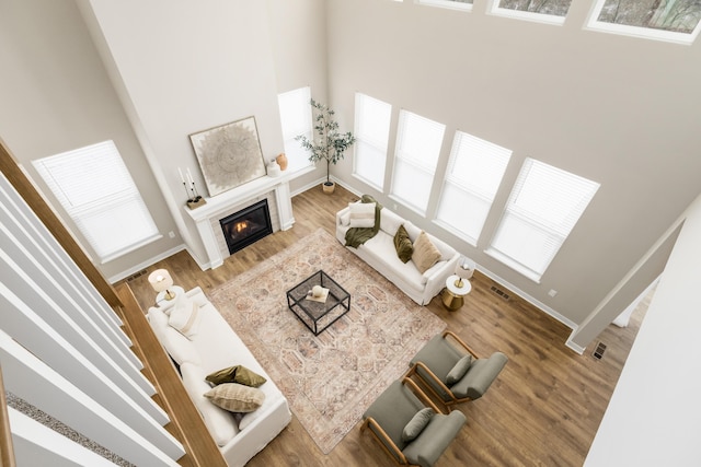 living room with wood-type flooring and a towering ceiling