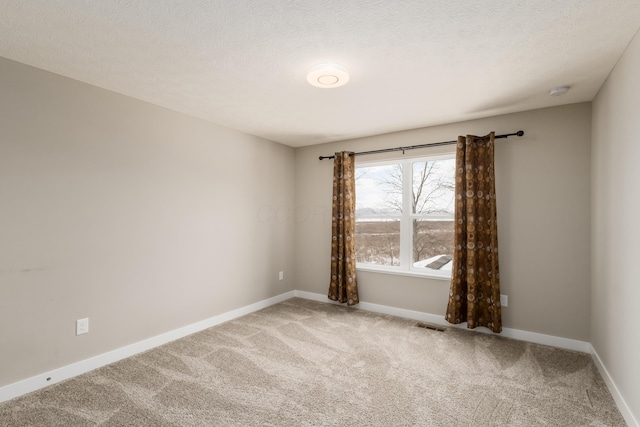 carpeted spare room featuring a textured ceiling