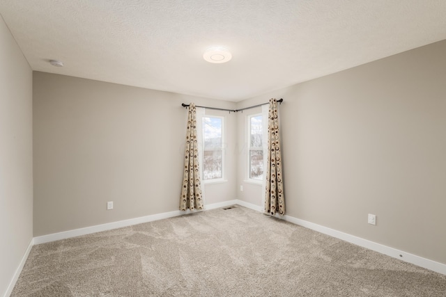 empty room with carpet floors and a textured ceiling