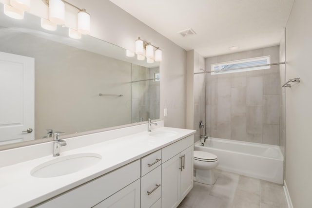 full bathroom featuring tiled shower / bath combo, toilet, and vanity