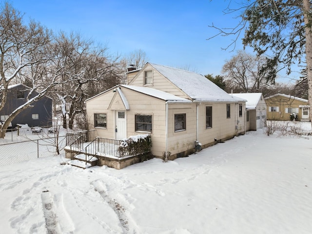 snow covered back of property with a wooden deck