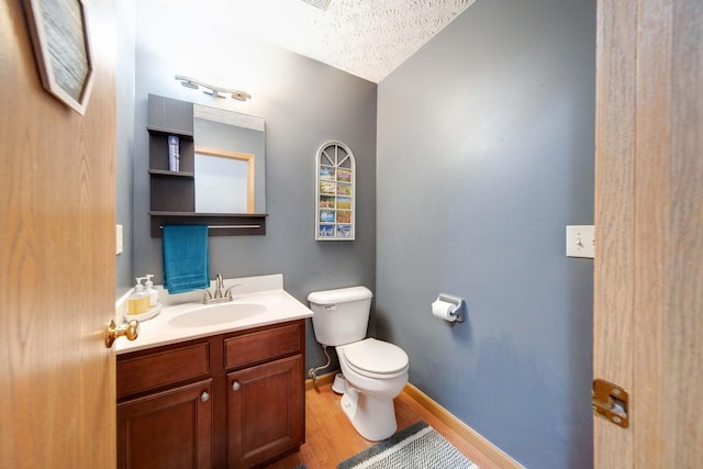 bathroom featuring hardwood / wood-style floors, vanity, a textured ceiling, and toilet