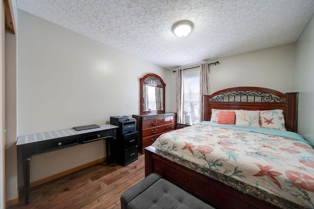 bedroom featuring a textured ceiling and dark hardwood / wood-style floors