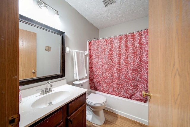 full bathroom featuring shower / bath combination with curtain, vanity, a textured ceiling, hardwood / wood-style flooring, and toilet