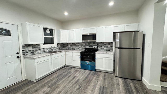 kitchen featuring white cabinets, sink, light stone countertops, and stainless steel appliances