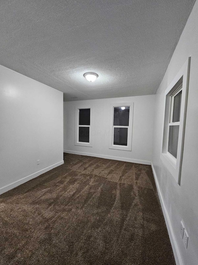 carpeted spare room featuring a textured ceiling