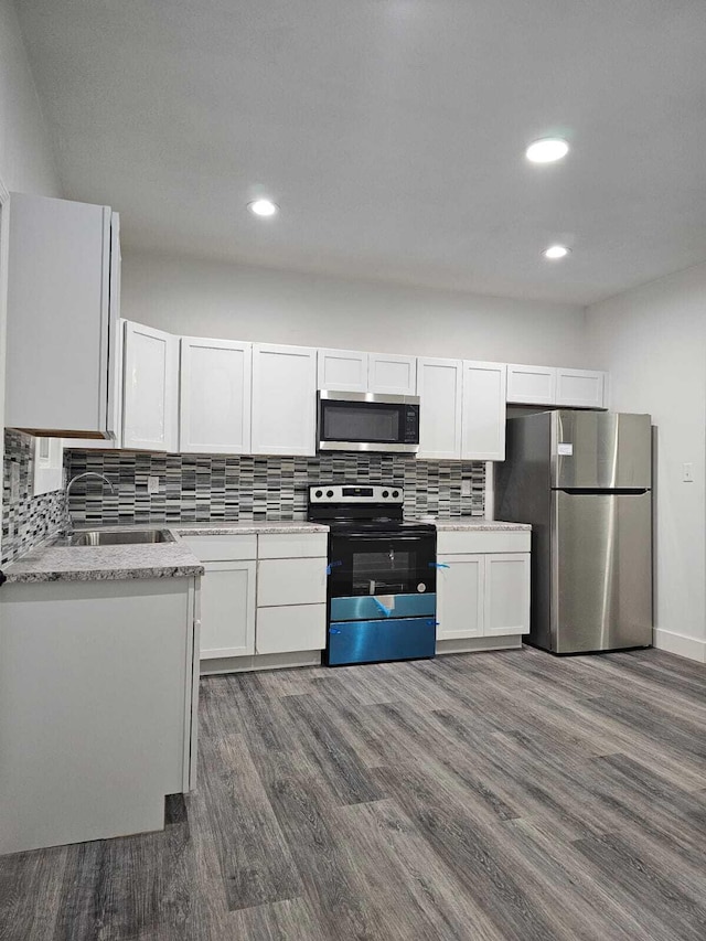 kitchen with dark hardwood / wood-style flooring, white cabinetry, sink, and stainless steel appliances