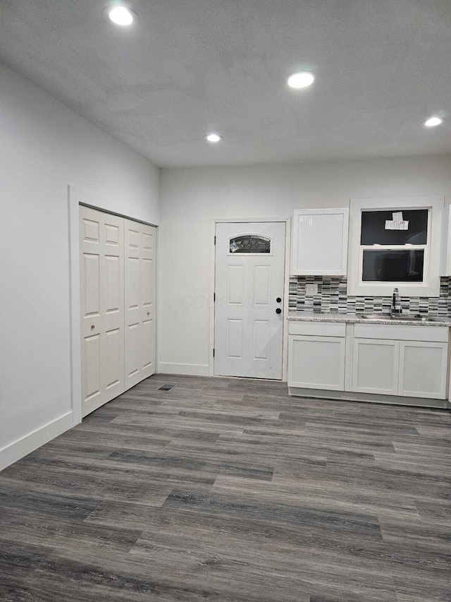 kitchen with tasteful backsplash, a textured ceiling, dark wood-type flooring, sink, and white cabinetry