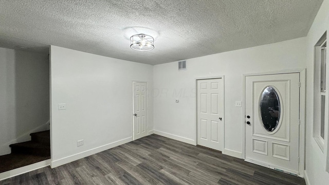 entrance foyer with a textured ceiling and dark hardwood / wood-style flooring