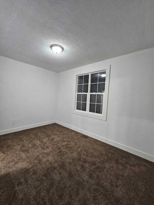 carpeted spare room with a textured ceiling