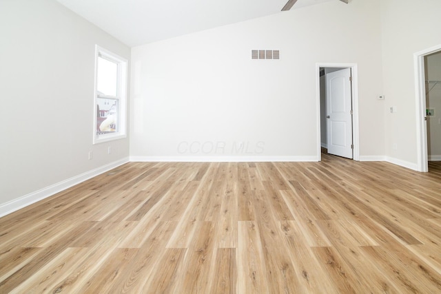 empty room featuring light wood-type flooring and lofted ceiling