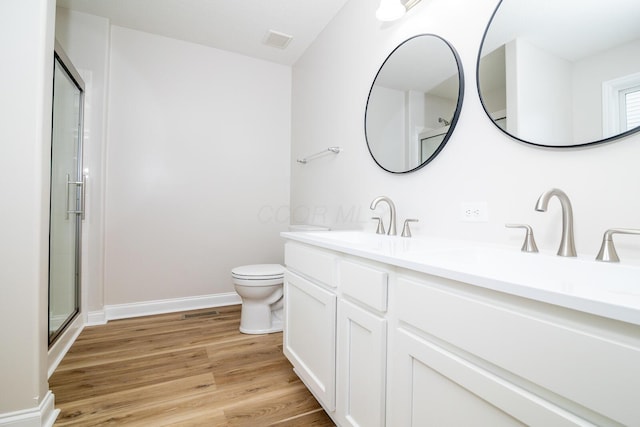 bathroom featuring hardwood / wood-style floors, vanity, toilet, and an enclosed shower