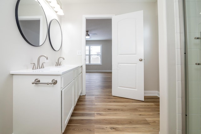 bathroom with ceiling fan, an enclosed shower, wood-type flooring, and vanity