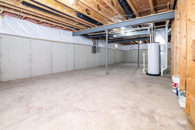 basement with electric panel, gas water heater, and brick wall