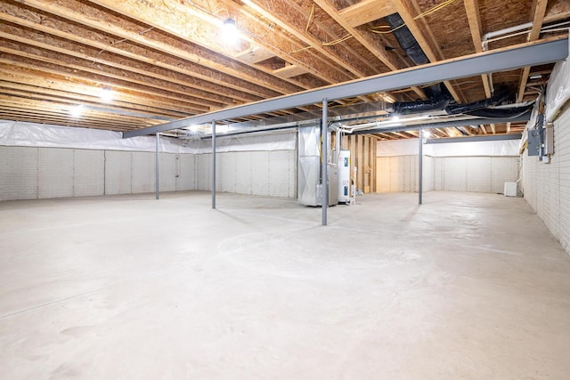 basement featuring brick wall and heating unit