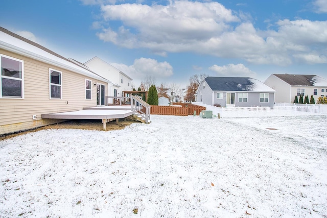 yard covered in snow with a wooden deck