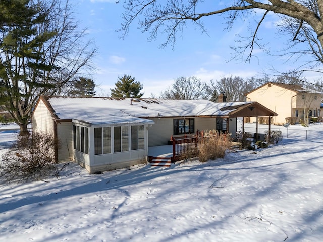 snow covered house with a sunroom