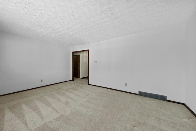 unfurnished room with light carpet and a textured ceiling