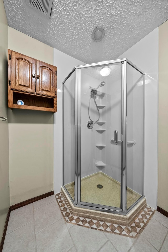 bathroom featuring a shower with door and tile patterned flooring