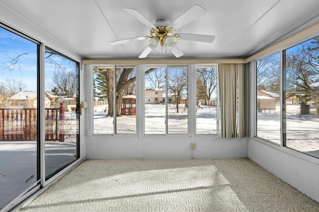 unfurnished sunroom featuring ceiling fan