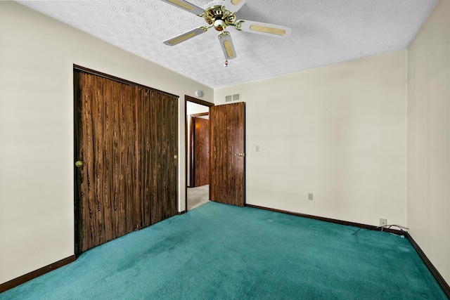 unfurnished bedroom featuring ceiling fan, a closet, carpet floors, and a textured ceiling