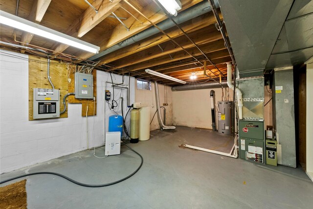 basement with electric panel, heating unit, and electric water heater