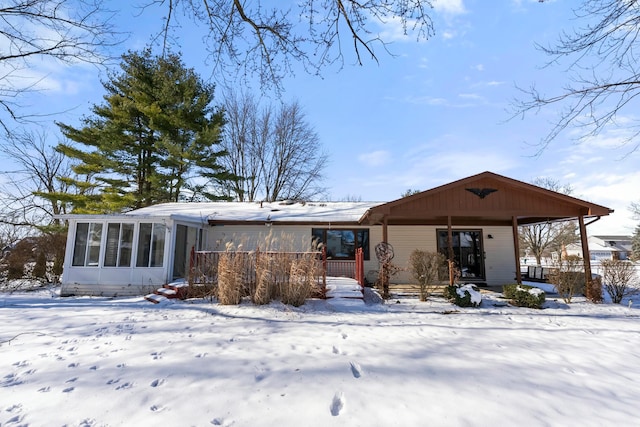 view of front of home with covered porch and a sunroom