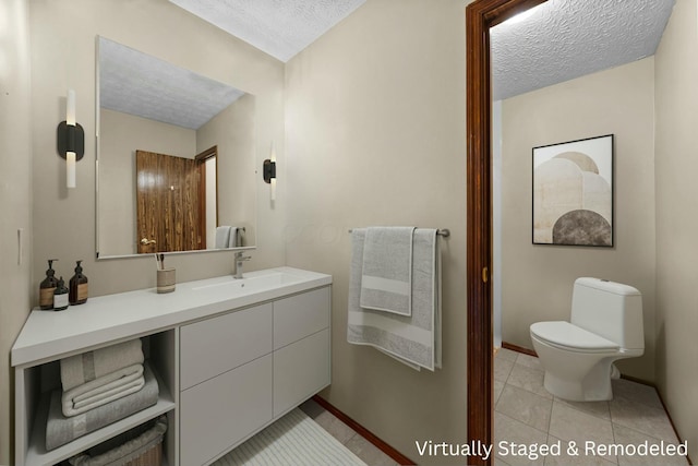 bathroom with a textured ceiling, toilet, tile patterned floors, and vanity