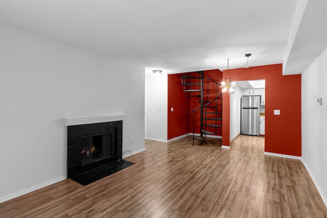 living room with a fireplace, a chandelier, and hardwood / wood-style flooring