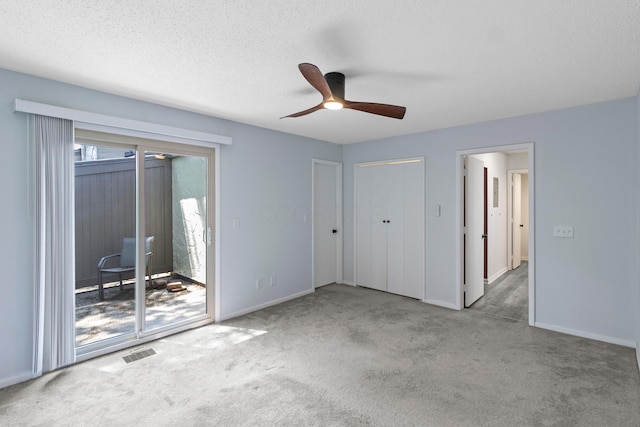 1301 Lake Shore Dr Unit 199, Columbus, OH 43204 - unfurnished bedroom featuring access to exterior, carpet flooring, a textured ceiling, and a ceiling fan