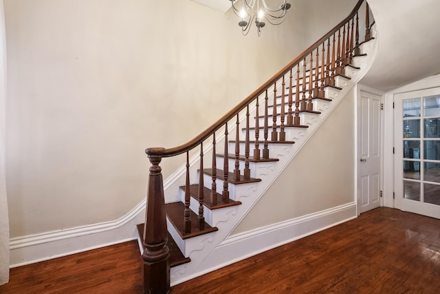 stairway featuring an inviting chandelier and hardwood / wood-style flooring