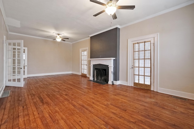 unfurnished living room with a brick fireplace, hardwood / wood-style flooring, ceiling fan, and ornamental molding