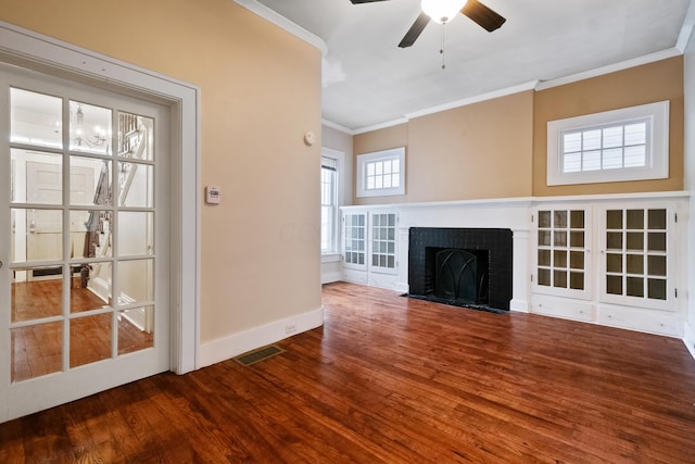 unfurnished living room featuring wood-type flooring, a brick fireplace, ceiling fan, and ornamental molding