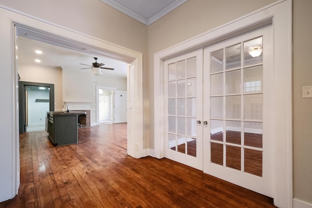 corridor featuring dark hardwood / wood-style flooring, ornamental molding, sink, and french doors