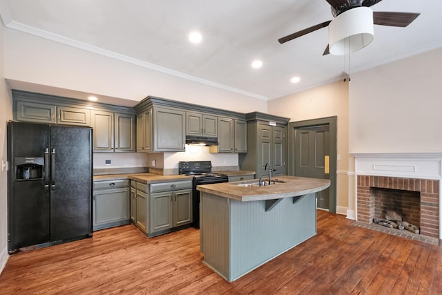 kitchen featuring sink, gray cabinets, a kitchen island with sink, and black appliances