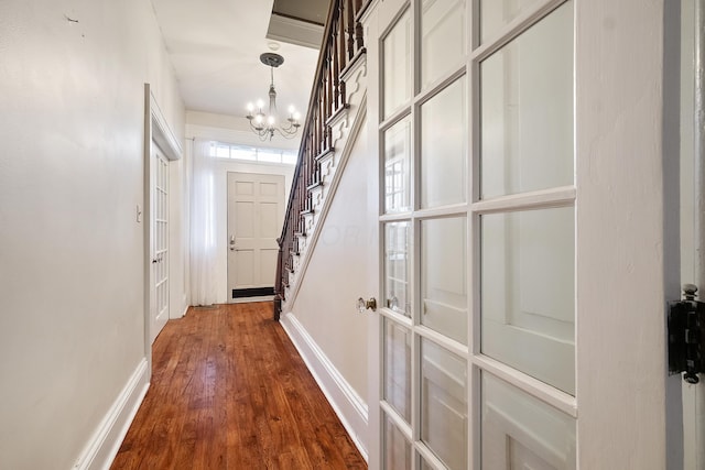 hallway featuring wood-type flooring and a chandelier