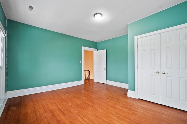 unfurnished bedroom with light hardwood / wood-style flooring and a closet