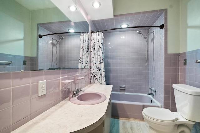 full bathroom with shower / bath combination with curtain, vanity, toilet, and tile walls