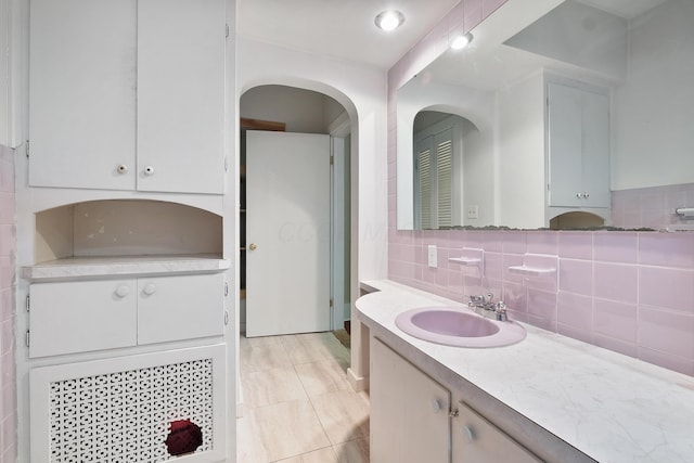 bathroom with tile patterned flooring, vanity, and tasteful backsplash