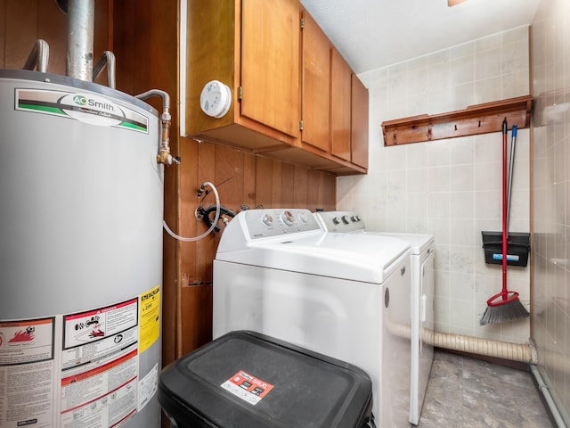 laundry area with cabinets, washer and clothes dryer, and gas water heater