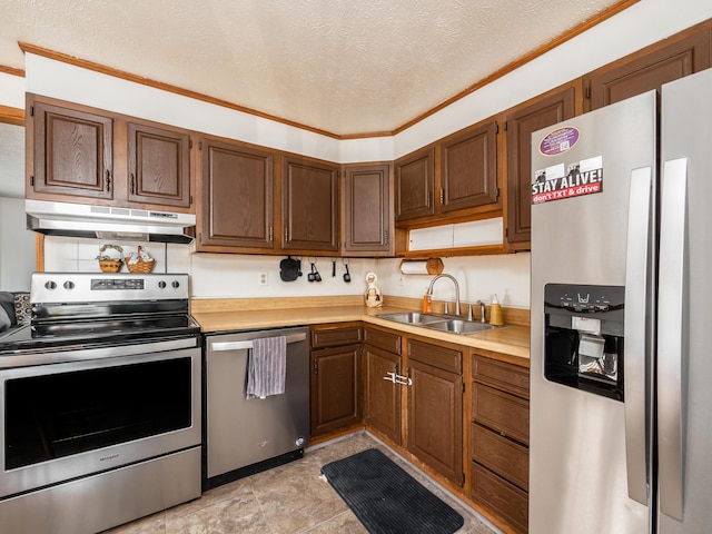 kitchen featuring appliances with stainless steel finishes, a textured ceiling, ornamental molding, and sink